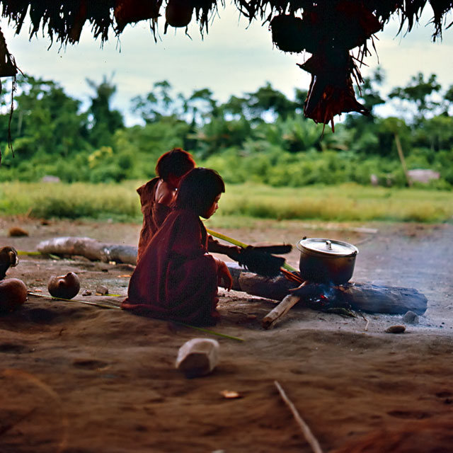 Ashaninka children fanning the flames of a campfire
